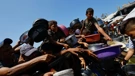 Palestinci čekaju kako bi preuzeli hranu iz humanitarne kuhinje