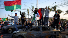 Prosvjednici na automobilu uništenom tijekom obračuna s policijom u okrugu Los Angeles, Foto: Daniel Cole/REUTERS