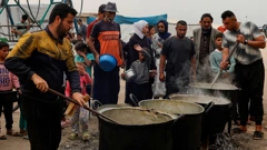 Palestinci čekaju hranu u javnoj kuhinji, Khan Younis, 8. travanj 2025.