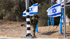 Izraelski vojnik stoji na ulazu u kibuc Kfar Aza